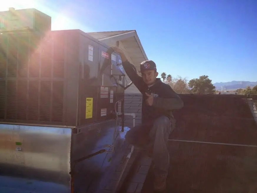 HVAC technician performing AC Tune-Up on a rooftop unit in Gages Lake